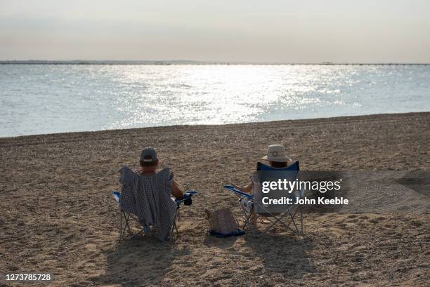 Couple sit on the beach in the late afternoon during the recent warm weather on September 20, 2020 in Southend on Sea, London.