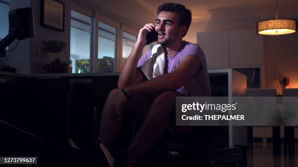 deserved break and making a phone call during rowing exercise sets - rowing machine home stock pictures, royalty-free photos & images