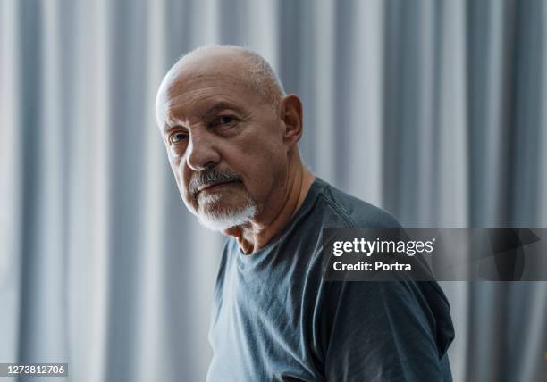 side view of wrinkled man sitting in bedroom - bed side view stock pictures, royalty-free photos & images