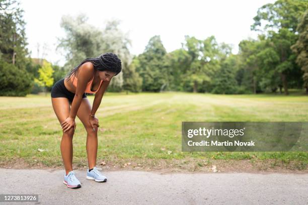 overtraining by young woman athlete taking a break - runner tired stockfoto's en -beelden