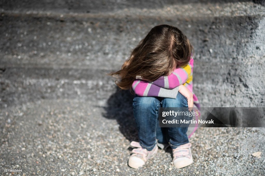 Isolated kid hiding her face from camera