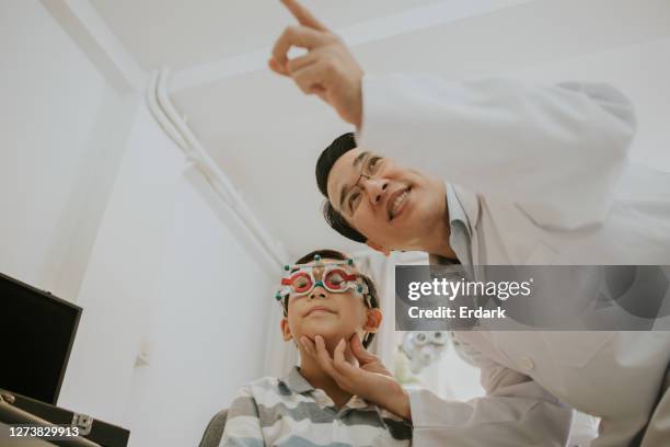 the ophthalmologist man with his patient boy-stock photo - ophthalmologist chart stock pictures, royalty-free photos & images