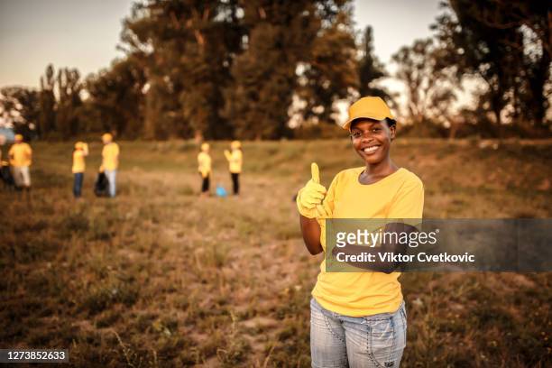 cute female volunteer cleaning garbage in nature - social justice concept stock pictures, royalty-free photos & images