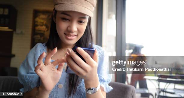 young woman sitting in coffee shop - very young thai girls stock pictures, royalty-free photos & images