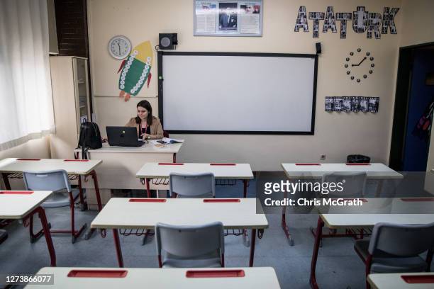 Second grade teacher Meltem Capkin sits in an empty classroom while conducting an online class at the Florya Ugur College on September 21, 2020 in...
