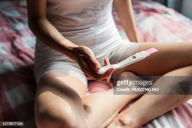 woman checking pregnancy test kit. - pregnancy test stock pictures, royalty-free photos & images