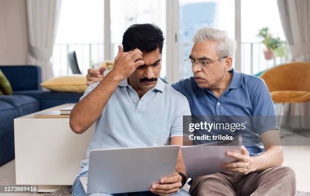 concerned father and son shocked by online information - emotional stress family stock pictures, royalty-free photos & images