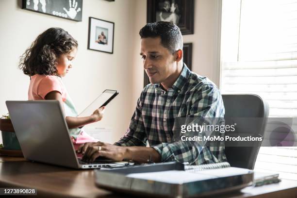 father working at home with young daughter - family phone tablet stock-fotos und bilder