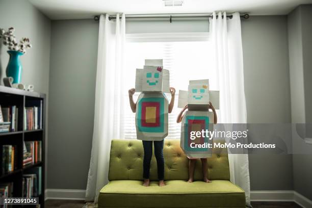 young girls wearing homemade robot costumes at home - onschuld stockfoto's en -beelden