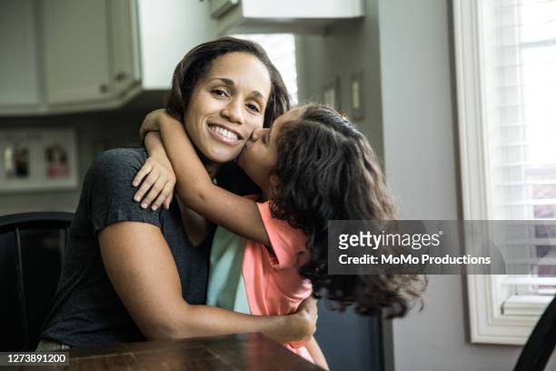 portrait of mother and daughter at home in kitchen - mother foto e immagini stock