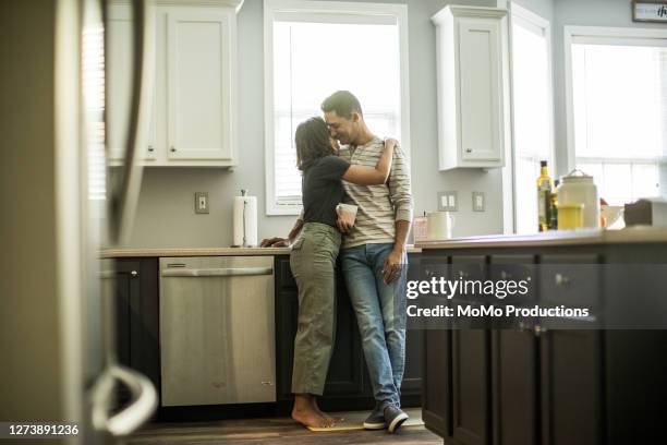 husband and wife talking in kitchen - woman day dreaming stockfoto's en -beelden