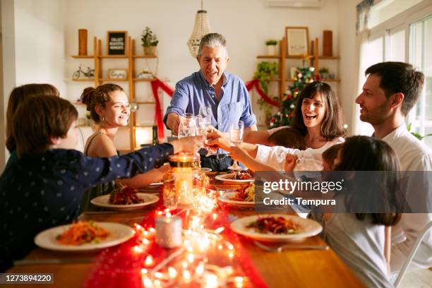 grandfather proposing a toast at christmas dinner in buenos aires - dinner stock pictures, royalty-free photos & images