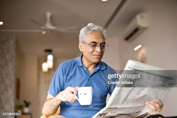 man drinking coffee and reading newspaper - smile paper stock pictures, royalty-free photos & images