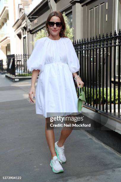 Guest wearing white dress, green snakeskin purse, sunglasses attends a OSMAN presentation at The Mandrake Hotel on September 21, 2020 in London,...