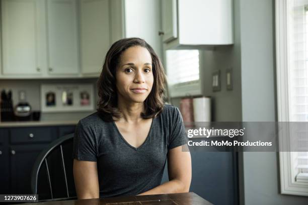 portrait of woman at kitchen table - anxious looking to camera fotografías e imágenes de stock