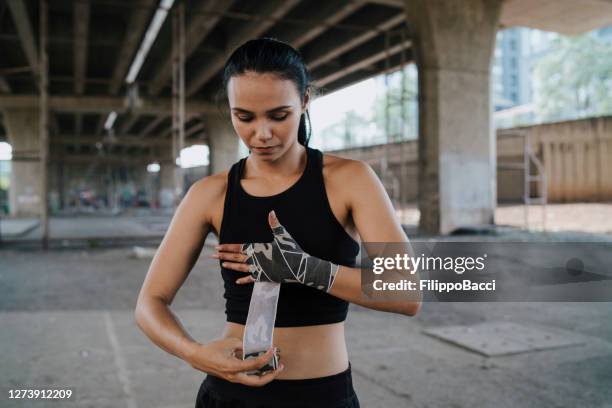 muay thai woman fighter wearing handwraps - boxing womens stock pictures, royalty-free photos & images