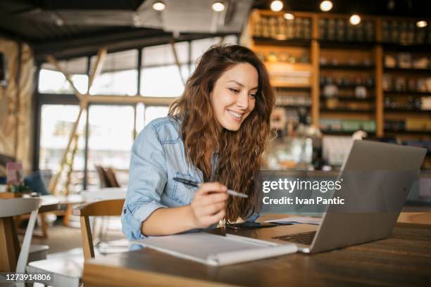 beautiful young caucasian woman working on her laptop - writing email stock pictures, royalty-free photos & images