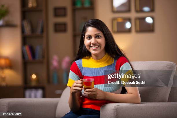 junge frau sofa sitzt zu hause - stockfoto - tee indien trinken stock-fotos und bilder