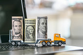 US USD 1, 5, 100 dollar bills, a trailer truck on a laptop