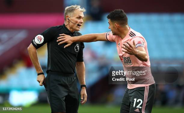 John Egan of Sheffield United appeals to match referee Graham Scott before he is shown a red card following a VAR review during the Premier League...