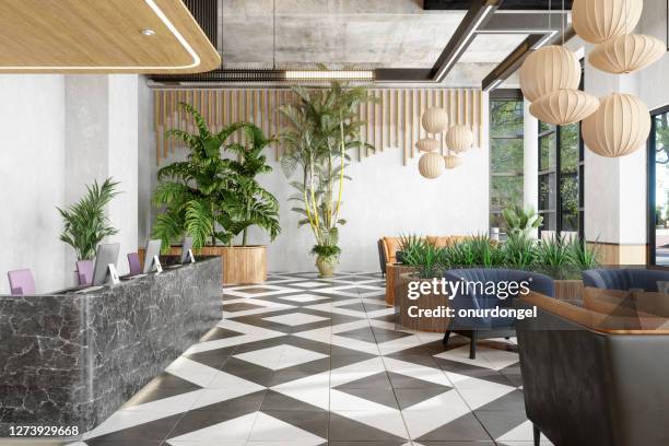 lobby with reception desk and lounge area with plants - luxury hotel lobby stock pictures, royalty-free photos & images