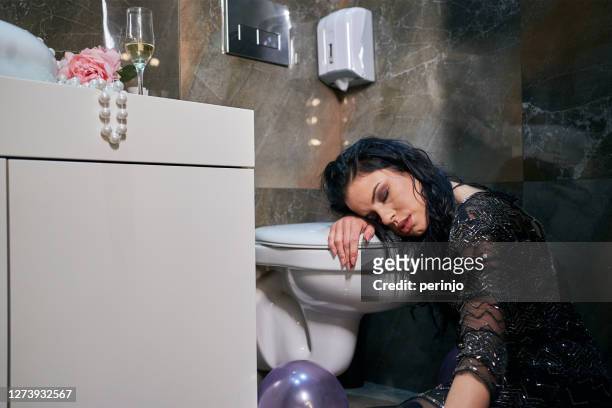 jovem bêbada dormindo no assento do vaso sanitário depois que ela vomitou - vômito - fotografias e filmes do acervo