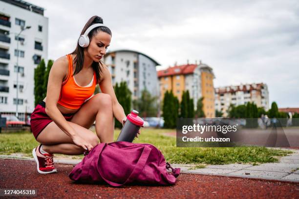 woman runner drinking water - duffle bag stock pictures, royalty-free photos & images