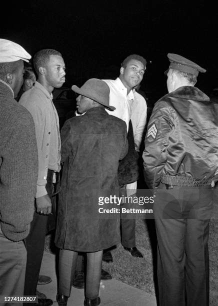 Cassius Clay taunts at the home of heavyweight champion Sonny Liston and yells, as his companions stare at the reporters gathered here at 1:00 a.m....