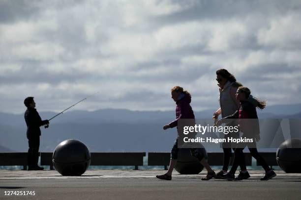 Pedestrians walk along the waterfront after a move to COVID-19 Alert Level 1 on September 22, 2020 in Wellington, New Zealand. Coronavirus...