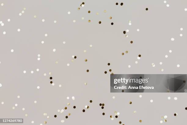 small golden confetti on gray background - espumillón fotografías e imágenes de stock