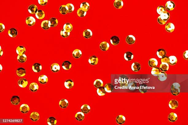 golden sequins arranged on red surface - sequin - fotografias e filmes do acervo