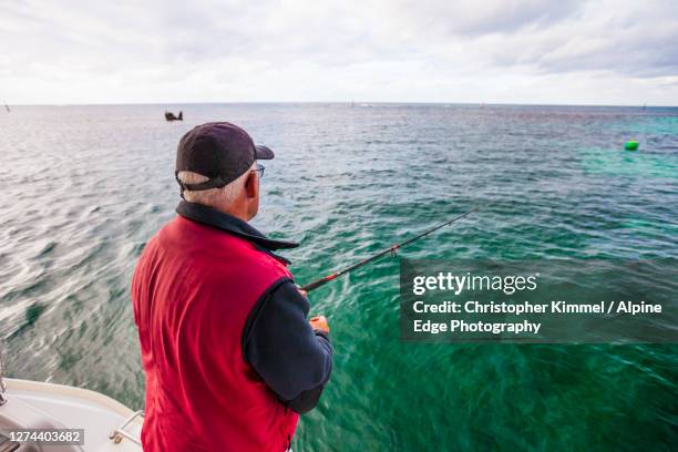 man fishing from sailboat, longreach bay, rottnest island, western australia, australia - longreach stock pictures, royalty-free photos & images