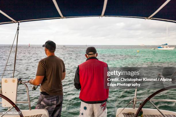 two men fishing from sailboat,longreachbay,rottnestisland, western australia, australia - fishing australia stock pictures, royalty-free photos & images