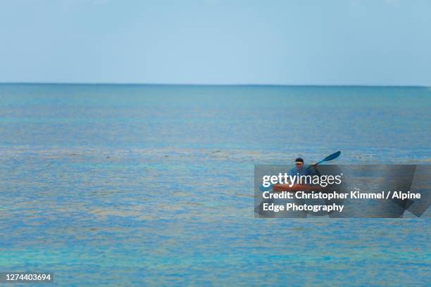 man paddling onwaveskiin sea, longreach bay, rottnest island, western australia, australia - longreach stock pictures, royalty-free photos & images