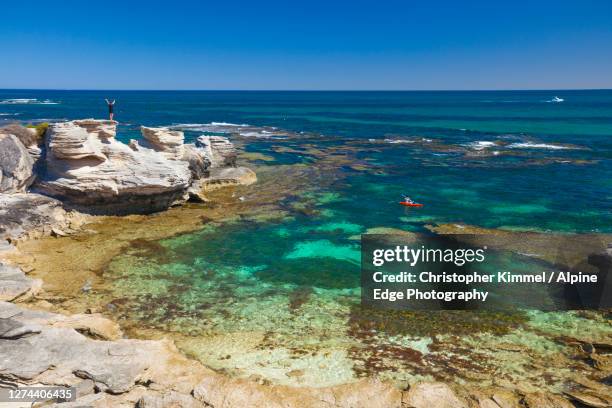 person overlooking kayaker from top of coastal rocks, perth, western australia, australia - paddleboarding australia stock pictures, royalty-free photos & images