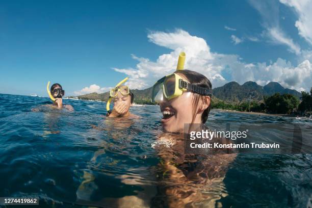 three women snorkeling,perebutan, bali, indonesia - asian group holiday stock pictures, royalty-free photos & images