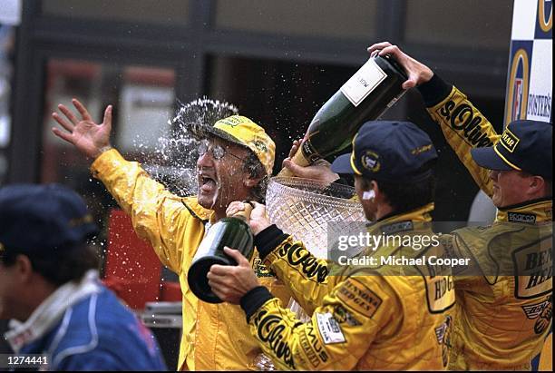 Jordan boss Eddie Jordan is sprayed with champagne by winner Damon Hill of Great Britain and Ralf Schumacher of Germany both of Jordan Mugen Honda at...