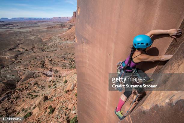side view of woman climbing rock, utah, usa - bears ears national monument stock-fotos und bilder