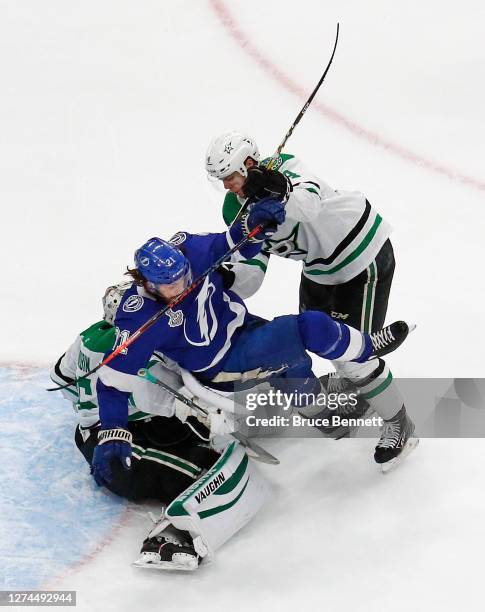 Brayden Point of the Tampa Bay Lightning is checked into Anton Khudobin by Miro Heiskanen of the Dallas Stars during the third period in Game Two of...