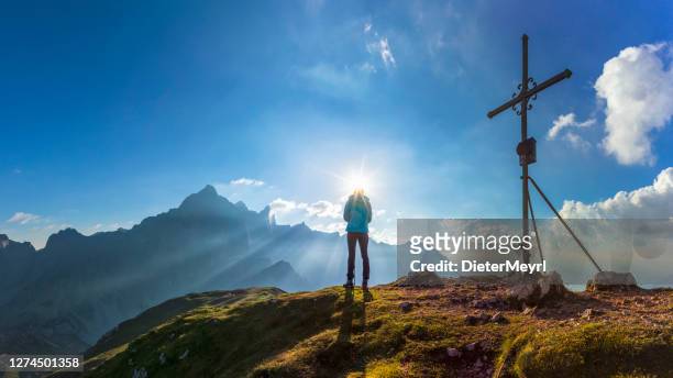 jonge vrouw voor topkruis - bergen dachstein, alpen - salzburgerland stockfoto's en -beelden