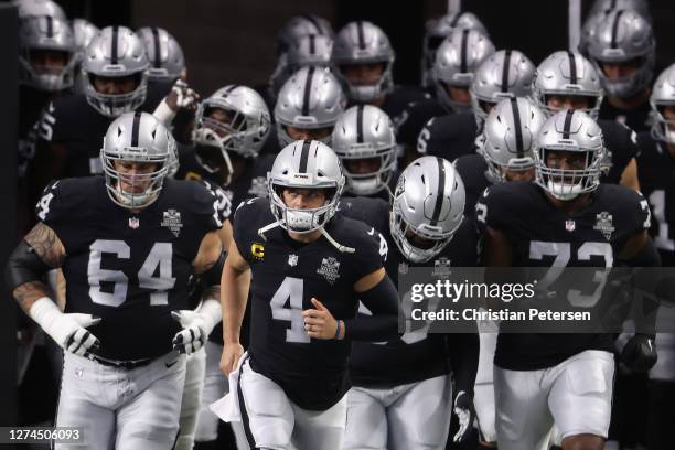 Quarterback Derek Carr of the Las Vegas Raiders runs onto the field with teammates before the NFL game against the New Orleans Saints at Allegiant...