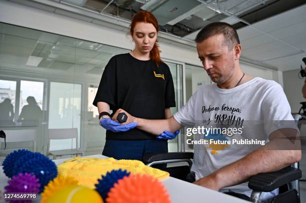 Serviceman of the Azov Regiment Oleksandr who partially lost his eyesight exercises under the supervision of an occupational therapist at the...