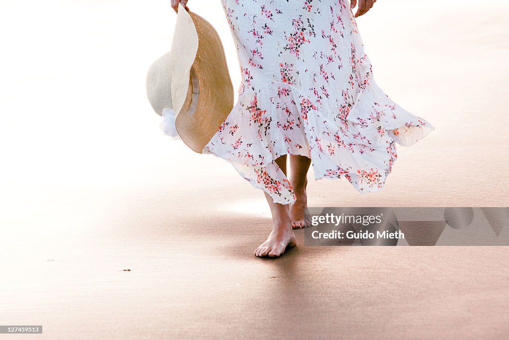 Young female is going through wet sand at beach