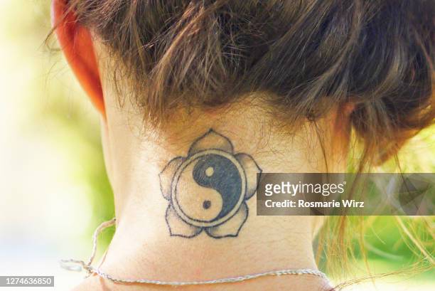 young woman with tattoo on nape - lotus flower tattoo stock-fotos und bilder