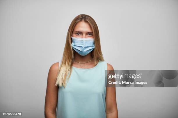 businesswoman wearing surgical face mask on white background - person studio shot stock pictures, royalty-free photos & images