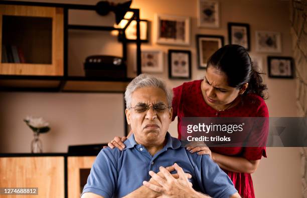 woman helping man having chest pain - problem stock pictures, royalty-free photos & images