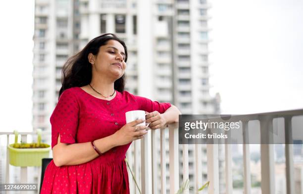 happy woman admiring view from balcony - women india partition stock pictures, royalty-free photos & images