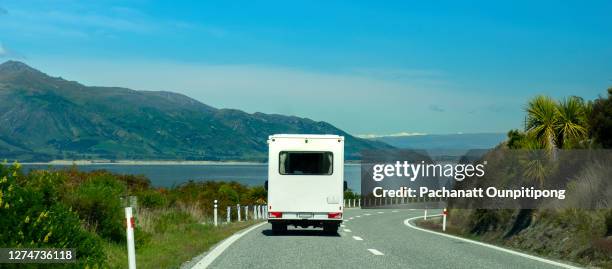 landscape of mountain, lake and one white motor home driving on road - summer camping new zealand stock pictures, royalty-free photos & images