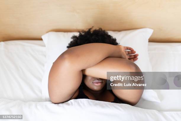sick woman sleeping in her bed - pillow over head 個照片及圖片檔
