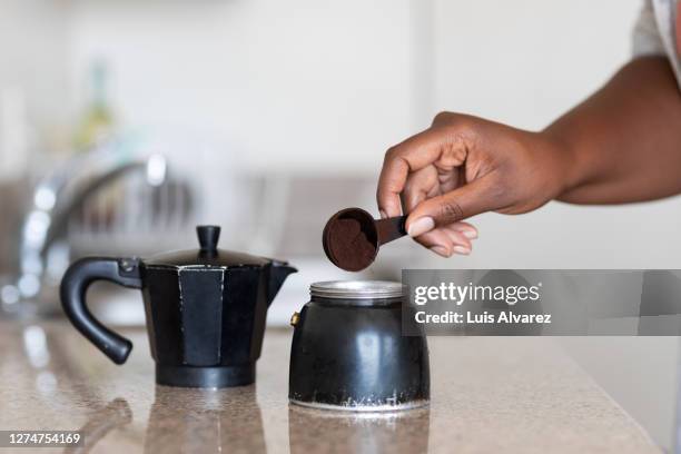 close-up of woman making coffee at home - spoon in hand stock-fotos und bilder